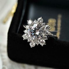 a diamond ring sitting on top of a velvet box