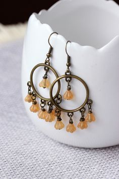 These lovely feminine boho earrings was made of yellow-brown czech glass flower shape beads, antique  brass round chandelier charms, brass jumping rings and antique brass earring hooks. Earring hooks are from nickel free and lead free metal. Perfect jewelry for your unique look or a great gift for someone special! *The total lenght of earrings is about 60 mm including earring hooks. Other earrings of my shop you can see here: https://www.etsy.com/shop/NaTavelli?section_id=13757927  Thanks for vi Bohemian Czech Glass Dangle Flower Earrings, Yellow Bohemian Nickel-free Flower Earrings, Brown Dangle Flower Earrings, Bohemian Brown Dangle Flower Earrings, Bohemian Amber Dangle Earrings, Yellow Bohemian Metal Earrings, Bohemian Gold Flower Bead Earrings, Bohemian Gold Flower Earrings With Round Beads, Bohemian Yellow Dangle Chandelier Earrings