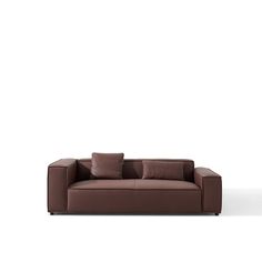 a brown leather couch with pillows on it's back and side, in front of a white background