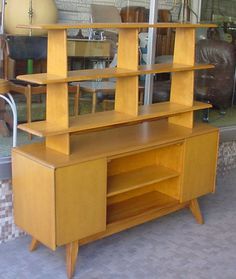 a large wooden shelf sitting in front of a glass window next to a brick wall