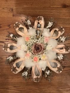 an arrangement of ballet shoes and flowers on a wooden floor in the shape of a snowflake