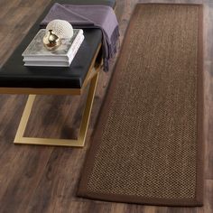 a brown rug on the floor next to a table