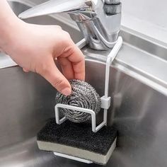 a person is cleaning a sink with a sponge and a microfit pad on it