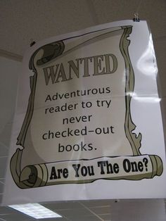 a sign hanging from the ceiling that says, wanted adventures reader to try check - out books are you the one?