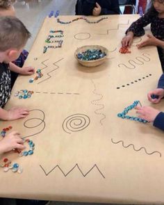 children are playing with beads on a table