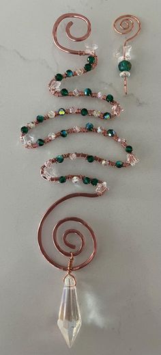 the necklace is made with wire, glass beads and metal spirals that are connected to each other