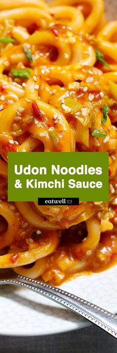 udon noodles and kimchii sauce on a plate with a fork next to it