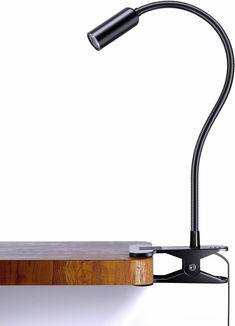 a desk lamp sitting on top of a wooden shelf next to a white wall and floor