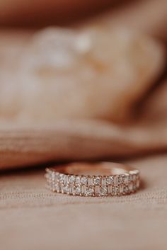 a diamond ring sitting on top of a bed