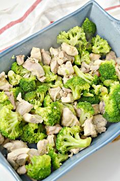 broccoli and chicken in a blue dish on a red and white tablecloth