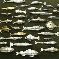 a collection of silver and gold fish on display