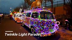 cars decorated with christmas lights are parked on the side of the road as people walk by