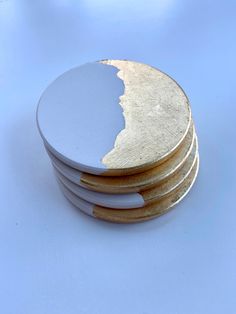 four white and gold coasters stacked on top of each other with one piece missing