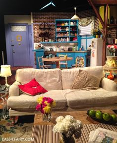 a living room filled with furniture and lots of colorful flowers on top of a table