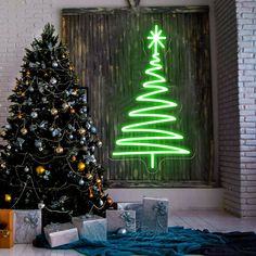 a decorated christmas tree in front of a neon sign with presents under it on the floor