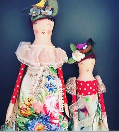 two dolls are dressed in colorful clothing and one is wearing a flowered headband