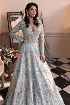 Ice Blue Pakistani Bridal Dress in Gown and Veil Style is a glamorous masterpiece adorned with hand-crafted details of shimmering embellishments and silverwork. Premium quality fabric and perfect stitching make this Pakistani Bridal Gown an epitome of beauty and grace. Pakistani Bridal Gown: Pakistani Bridal Gown in an alluring ice blue color has open style has premium net fabric. This stunning Pakistani Gown is gracefully emblazoned with silverwork and shimmering embellishments. Beads, motifs, sequins, floral motifs, and intricate designs make this Gown a perfect choice to wear on the most important day of your life. The gown is perfectly stitched as per the customer's choice and it gives a glamorous wedding look to the gorgeous bride. Bridal Veil: Pakistani Wedding Dress in Net Gown styl Blue Pakistani Bridal Dress, Bridal Gown Pakistani, Bengali Wedding Dress, Gown Pakistani, Pakistani Gown, Net Gown, Pakistani Bridal Dress, Net Gowns, Shadi Dresses