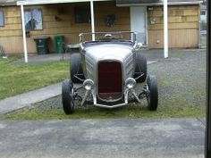 an antique car parked in front of a house