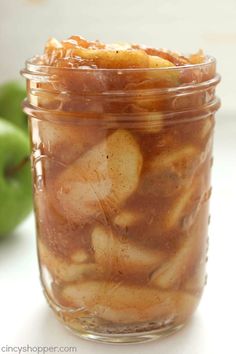 a jar filled with apple slices sitting on top of a table