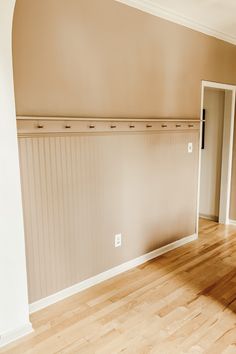 an empty room with wooden floors and white walls