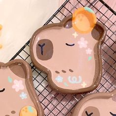 three cookie shaped like animals sitting on top of a cooling rack next to each other