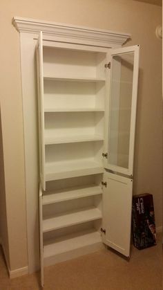 an empty closet is shown with shelves and doors open to reveal the bathroom's amenities