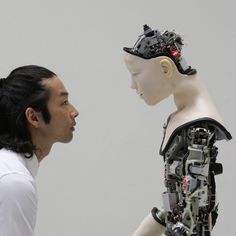 a man standing next to a mannequin head