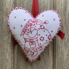 a heart shaped ornament hanging on a wooden wall