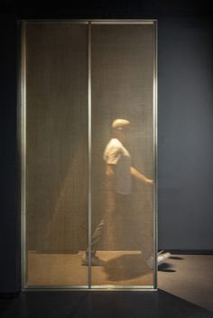 a man standing in front of a glass door with his foot on the ground next to him