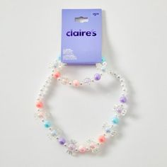 the beads are made from plastic and have different colored stones on each strand, which is attached to a card board