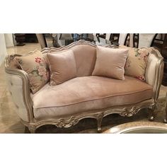 a couch with pillows on it in a room full of other furniture and decor items