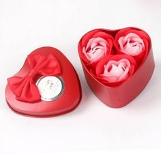 a red heart shaped box with roses in it