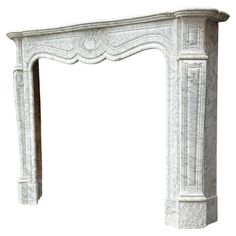 a white marble fireplace mantel with ornate carvings on the top and sides, isolated against a white background