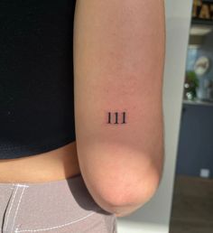 a woman's arm with the number 11 tattooed on her left side, in black ink