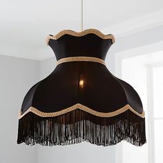 a black and gold chandelier hanging from the ceiling in a room with white walls