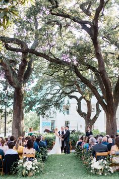 a couple getting married under the trees at their wedding