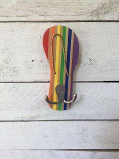 a multicolored umbrella hook on a white wooden wall