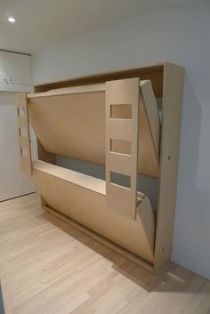 a wooden bunk bed sitting on top of a hard wood floor next to a white wall