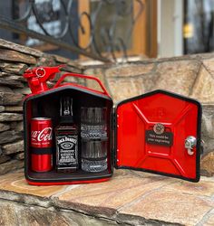 a red case with two bottles in it sitting on a stone ledge next to a brick wall