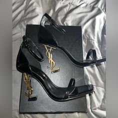 New! Yves Saint Laurent Opium Heels Size 6.5.. Black Patent Leather With Gold.. Sticker Under Heel To Preserve Haven’t Worn, Only Try On Inside The House!!! Comes With Box & Shoe Bagprice Is Firm, These Heels Are Very Expensive To Be Low Balling! To Ppl That Are Questioning; Do Your Research: The Bottom Of These Shoes Are A Protective Sticker That’s Attached To Preserve The Shoes So No They Have Not Been Worn!!! It’s How I Received When I Purchased These Were Purchased Here Through Another Poshe Black Heels With Gold Accent, Gold Heels Black Dress, Shoe Inspo Heels, Knife Heels, Expensive Heels, Yves Saint Laurent Heels, Black Heels Pumps, Strap Heels Black, Saint Laurent Heels