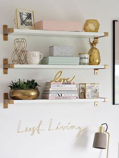 the shelves are filled with books and other decorative items in gold, white, and pink