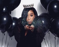 a woman wearing a tiara surrounded by balloons