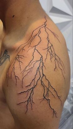 a man's chest with lightning tattoo on it