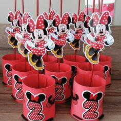 mickey and minnie mouse cupcake toppers on sticks with red paper cups in the middle