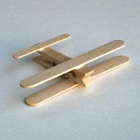 a pair of wooden clothes pegs sitting on top of a white surface with snow