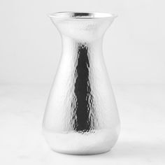 a silver vase sitting on top of a white table