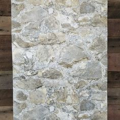 a stone wall with wood planks in the background