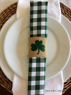 a place setting with a napkin holder decorated with a shamrock