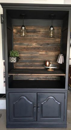 an entertainment center made out of wood and metal, with two lights on each side