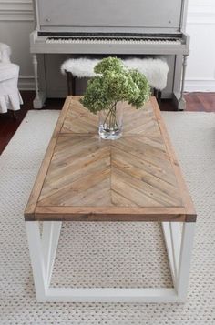 a living room with a piano in the background and a coffee table that has flowers on it